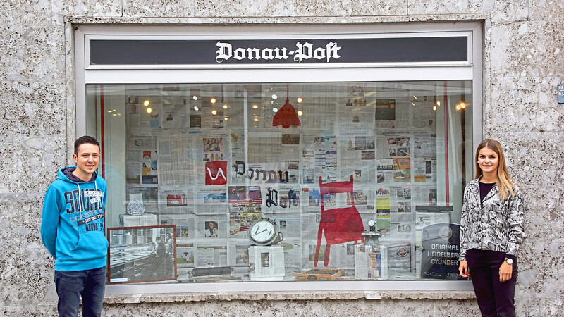 Vera Seidel und David Lautner von der Mediengruppe Attenkofer vor dem fertig dekorierten Schaufenster der Donau-Post.