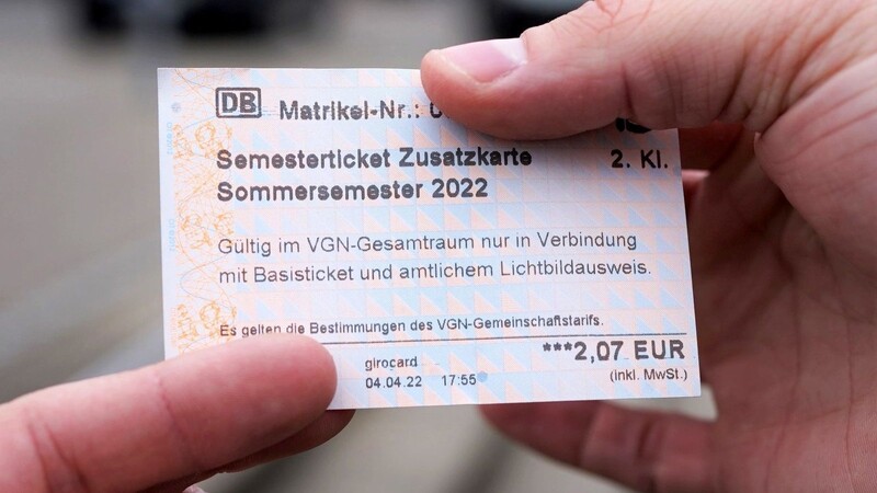 Ein Student hält ein Semesterticket für den Verkehrsverbund Großraum Nürnberg.