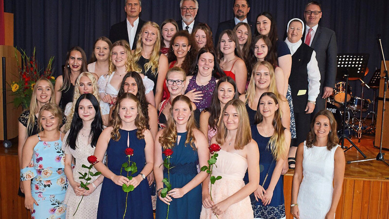 Die Abschlussklasse, im Vordergrund - mit Rosen - die Jahrgangsbesten, von links nach rechts: Julia Aigner, Nadine Dietl, Laura Brunner, Evelyn Richter. Letzte Reihe, von links nach rechts: Konrektor Robert Gruber, Schulleiter Wolfgang Zirm, 2. Bürgermeister Adalbert Hösl, Generaloberin Sr. Anita Heimerl und Landtagsabgeordneter Josef Zellmeier.