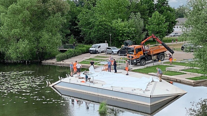 Jetzt liegt das Bühnensegel auf der Plattform - die vier Stangen sind bereits abgebaut - und muss nun richtig gefaltet werden.