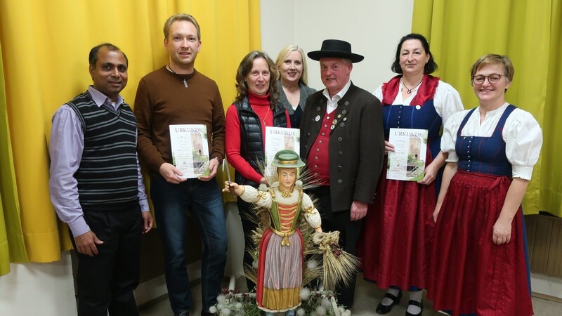 Vorstände und Ehrengäste mit einem Teil der Geehrten (mit Urkunde): Pater Joseph (v.li.), Günter Kreusel, Irene Baier, Bürgermeisterin Josefa Schmid, Kulturreferent Edi Baier, Claudia Heigl und Vorständin Sigrid Penzkofer. Davor die Statue der Heiligen Notburga.