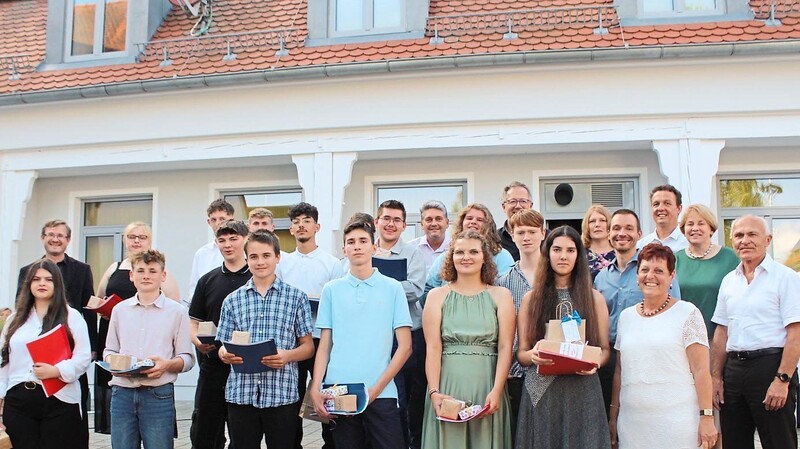Glücklich sind die Absolventen nach der Zeugnisvergabe, mit im Bild die Ehrengäste, die Schulleitung und Klassenlehrer Andreas Karg (links)