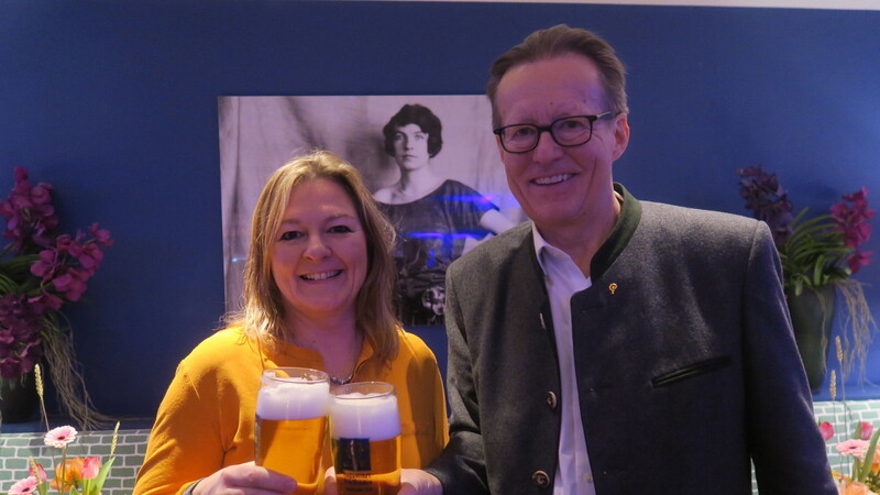 Ein Prost auf die Stiftungs-Gründerin Edith Haberland, die auf dem Bild im Hintergrund zu sehen ist. Vorne stoßen Wiesn-Stadträtin Anja Berger (Grüne) und Augustiner-Chef Martin Leibhard mit einem frisch gezapften Augustiner an.