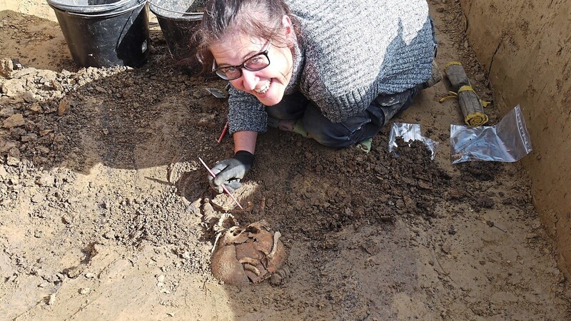 Ausgrabungsleiterin Sabine Kunz legt mit höchster Sorgfalt und Präzision den Schädel eines Skelettes frei.