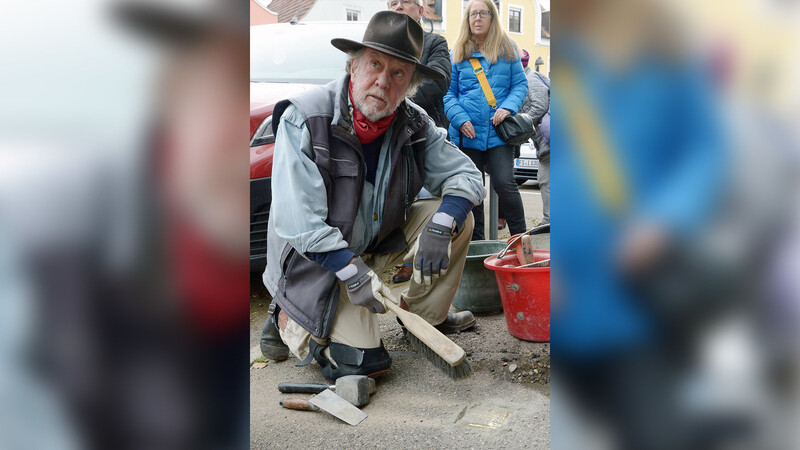 Gunter Demnig beim eigenhändigen Verlegen des Stolpersteins für Alois Weiner.